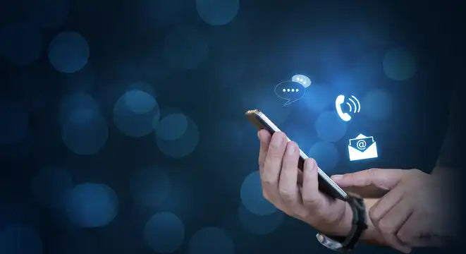 Hand holding smartphone with contact icons.